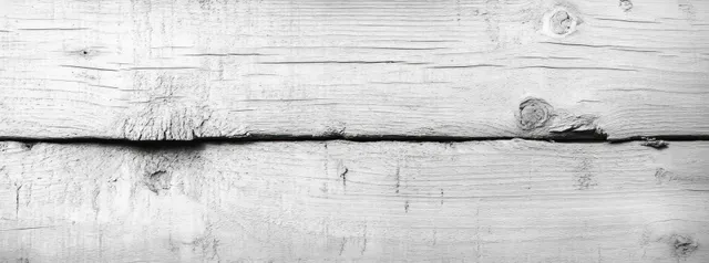 Weathered white painted wooden planks with visible grain, knots, and surface cracks in close-up.