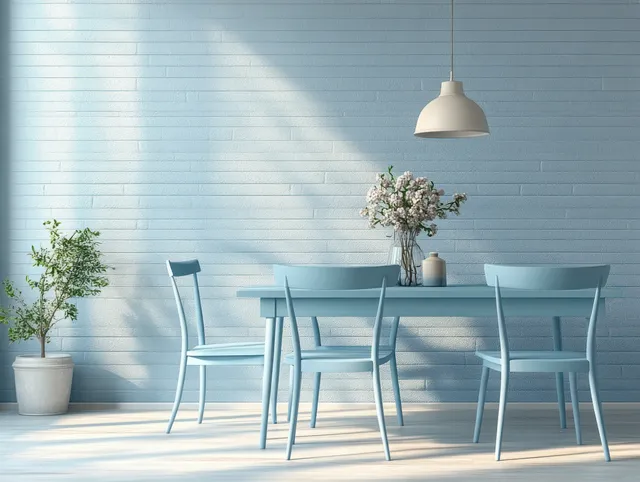 Light blue dining table and chairs arranged against a sunlit pale brick wall with potted plants.