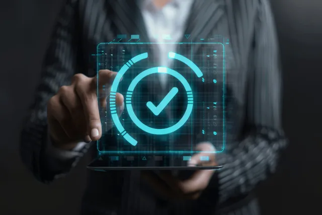 Profesional de negocios sostiene una tableta con una interfaz brillante de control de calidad con marca de verificación virtual y UI de documento.