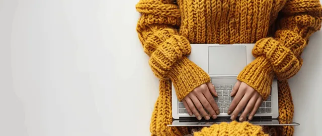 Woman typing on laptop from above in a minimal home workspace