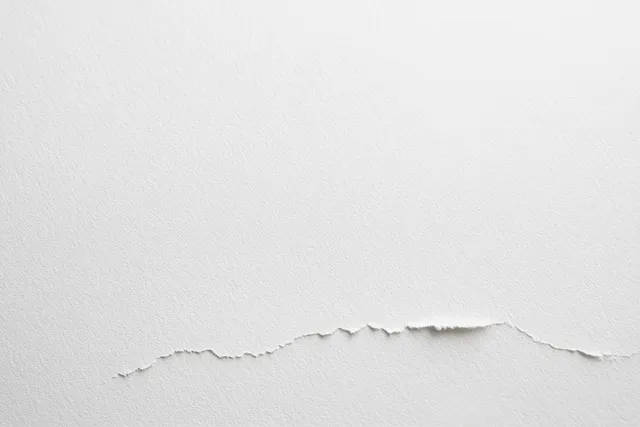 White paper texture background with torn edge, close-up on smooth parchment fibers