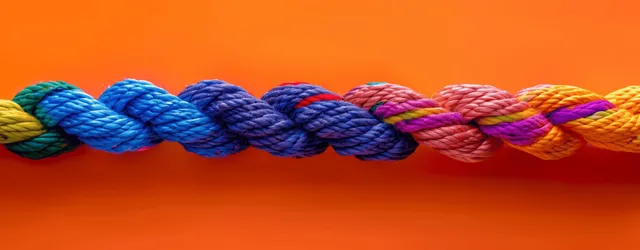 Colorful braided rope strands interweave into a unified loop against a vivid orange background.