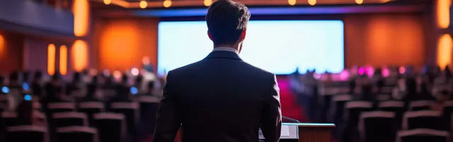 Back view of a presenter delivering a technology forecast talk in a conference hall