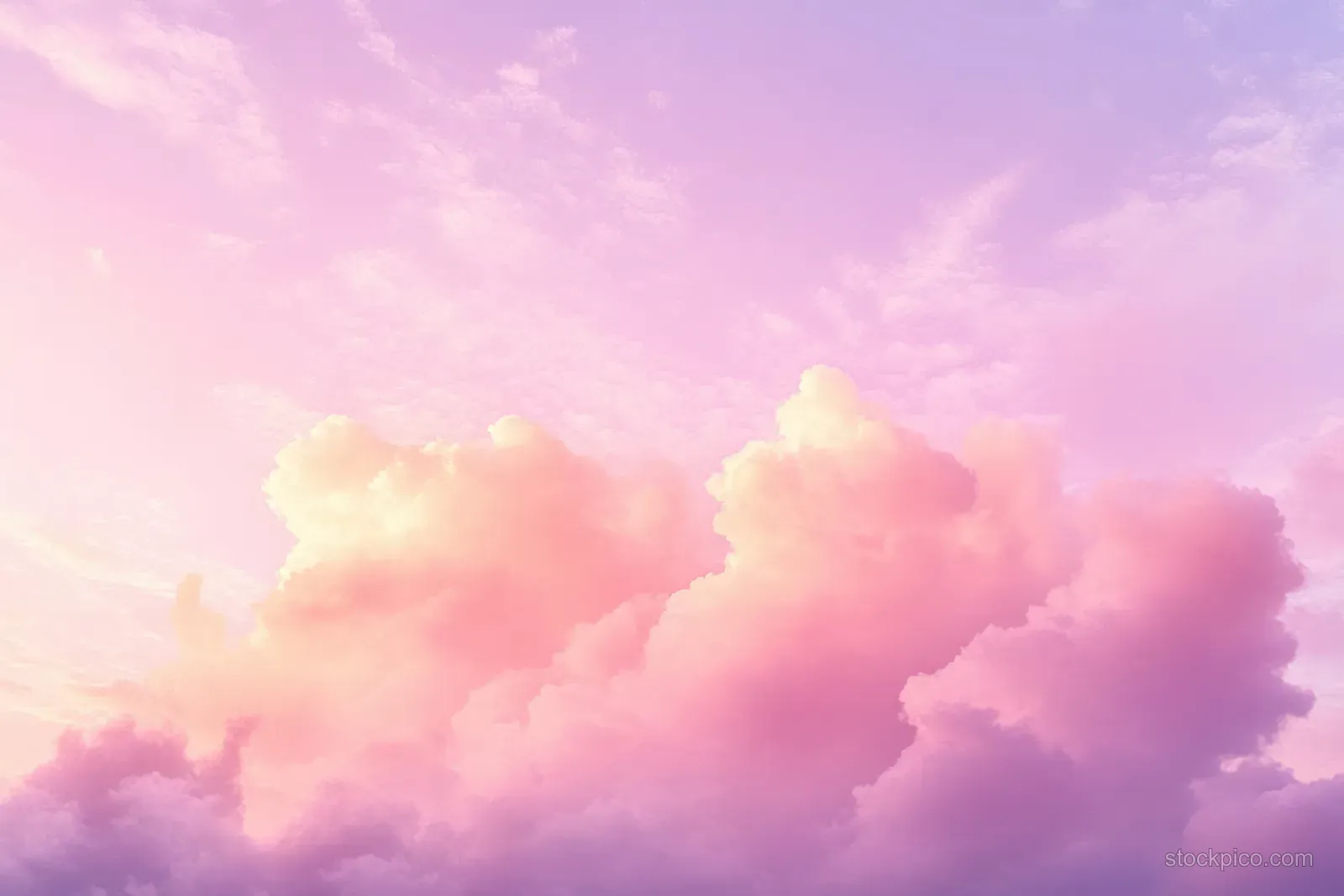 Pink and purple fluffy cumulus clouds drift across a pastel blue sky during sunrise.