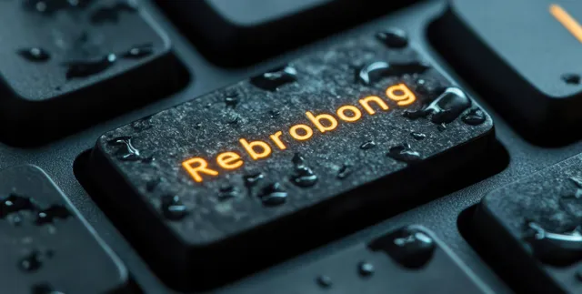Wet black keyboard key with the “Rebrobong” word illuminated orange and covered in water droplets.