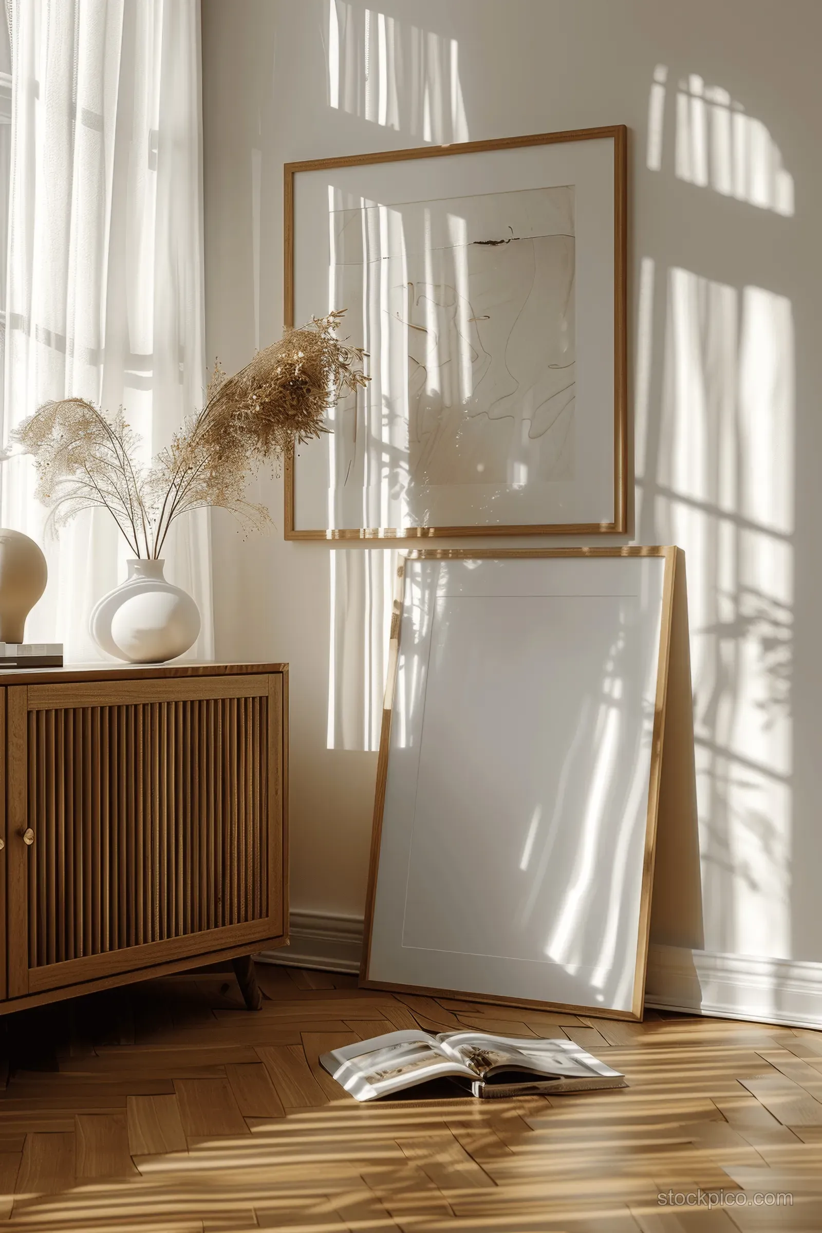 Sunlit living room with wooden sideboard, sheer curtains, and an empty gold-framed wall poster.