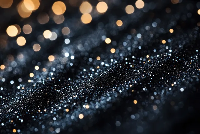Black glitter bokeh lights scatter across a dark vintage textured background surface