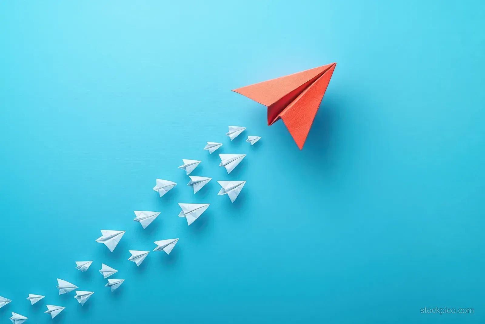 A red paper airplane leads a row of small white paper planes across a blue gradient background.