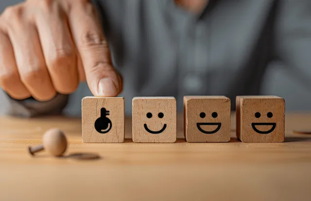 Customer service team building trust by arranging smile and neutral customer icons on blocks