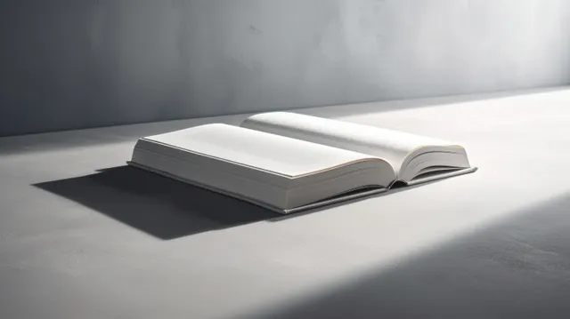 Open white book lying on a soft gray surface with crisp shadows and minimalist lighting.
