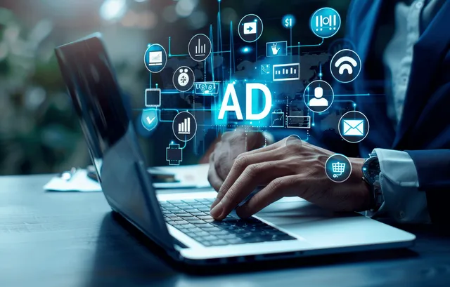 A person typing on a laptop as floating ad, analytics, and email icons appear on the screen.