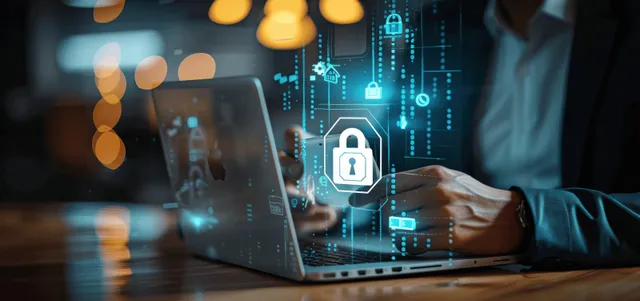 Businessman using laptop and smartphone with digital lock icons for cybersecurity.