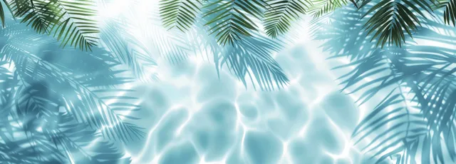 Palm leaf shadows ripple across sunlit blue water with bright sky reflections