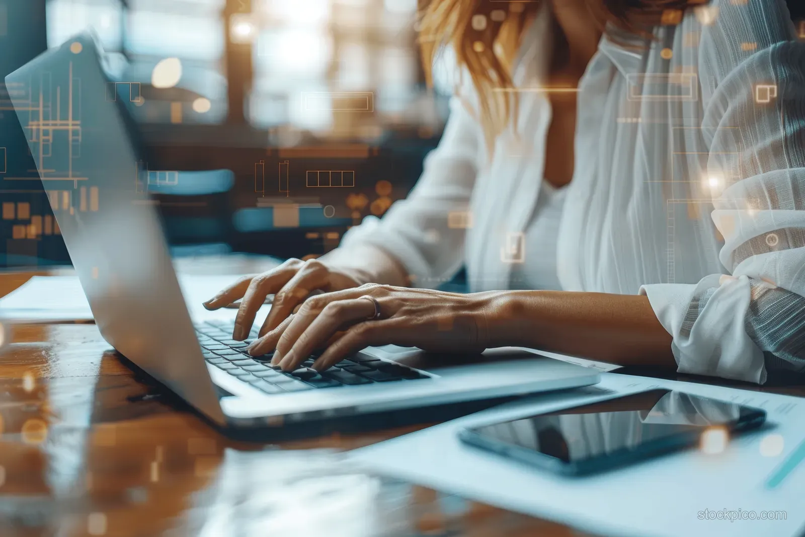 Businesswoman typing on a laptop at a cafe table with documents and a smartphone nearby.
