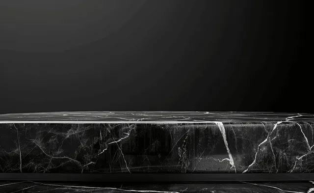 Black marble tabletop on a dark background with white marble veining lines and soft shadowed stage.