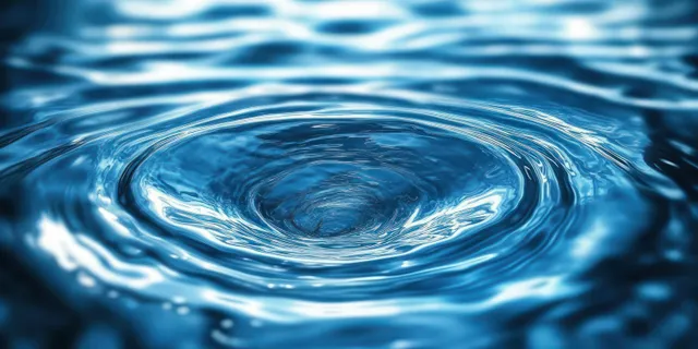Swirling water vortex on deep blue surface with concentric ripples and crisp reflections