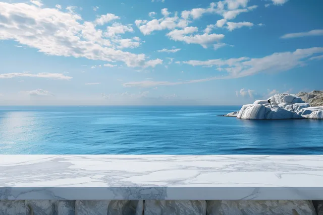 White marble tabletop in front of a blurred ocean horizon and blue summer sky.