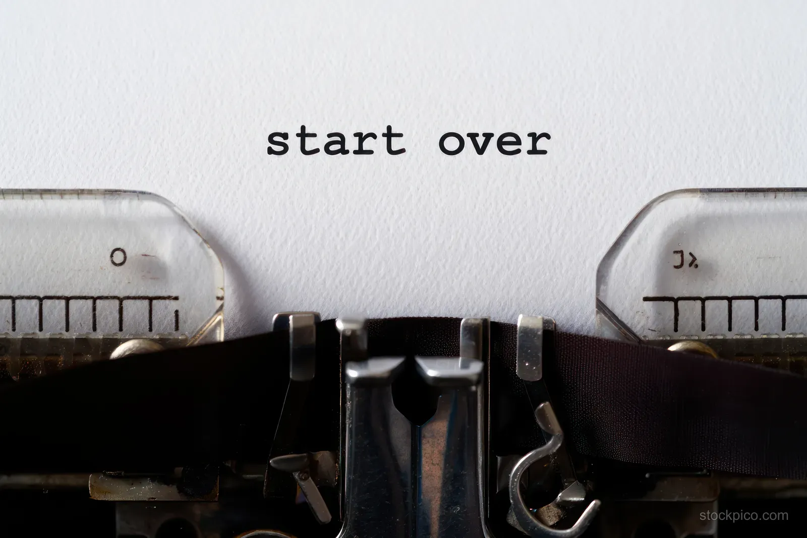 An old typewriter types the words “start over” onto white paper in a close-up view.