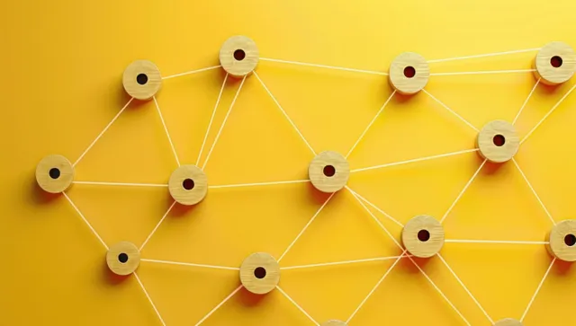 Wooden circular nodes connected by white strings form an interconnected network on a bright yellow background.