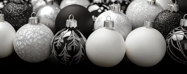 Black and white Christmas ornaments with gold details sit closely together on a dark sparkling background.