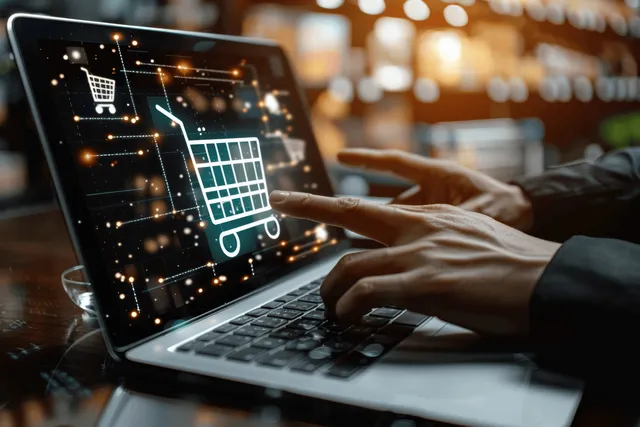 Businessman tapping smartphone while laptop shows hologram cart checkout in home office