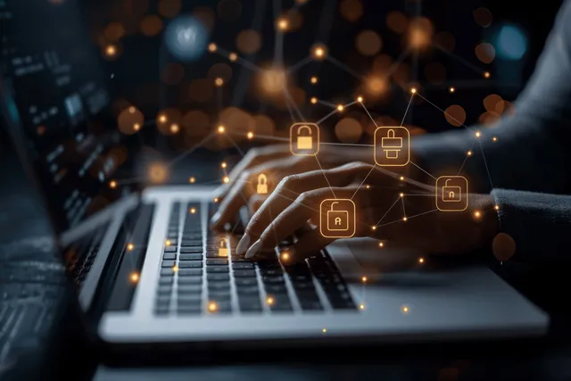 Hand typing on laptop as padlock icons float over a cyber security interface