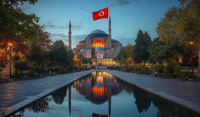 Illuminated historic mosque entrance with two minarets, reflected in a long pool at twilight