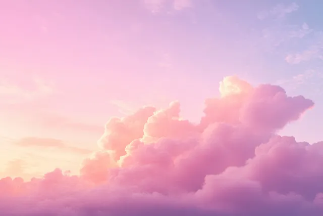 Fluffy pink and purple clouds glowing in soft sunset light over a calm horizon