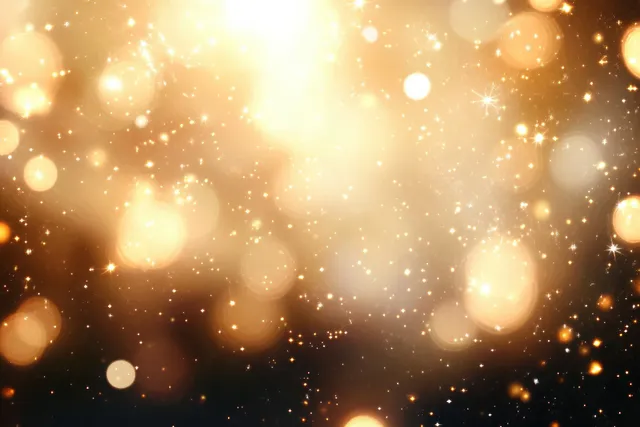 Golden and white bokeh lights floating across a soft glowing abstract background