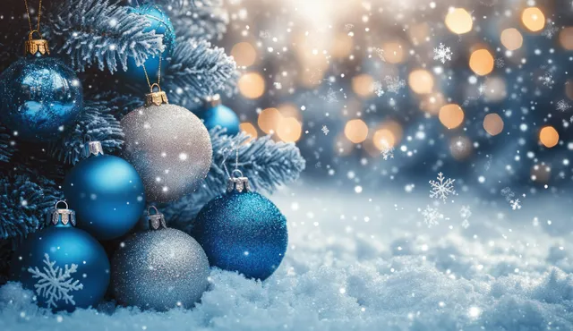 Blue and silver Christmas ornaments on snowy pine branches with falling snowflakes and warm bokeh lights.