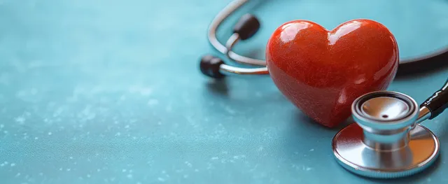 Red heart with stethoscope on turquoise medical background for heart health awareness