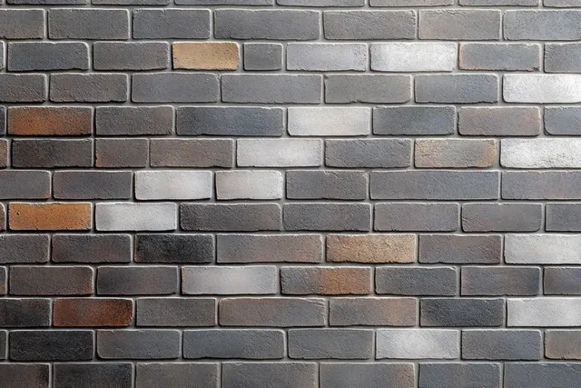 Close-up of a multitone brick wall with gray, brown, and beige rectangular bricks aligned in horizontal rows.