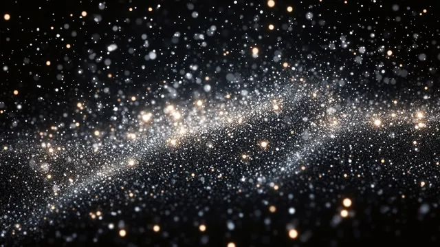 Glowing particles scatter across dark space, forming a luminous galaxy cloud with soft bokeh light spots.