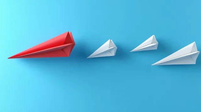 Red paper airplane leader with white team flying forward on bright blue background