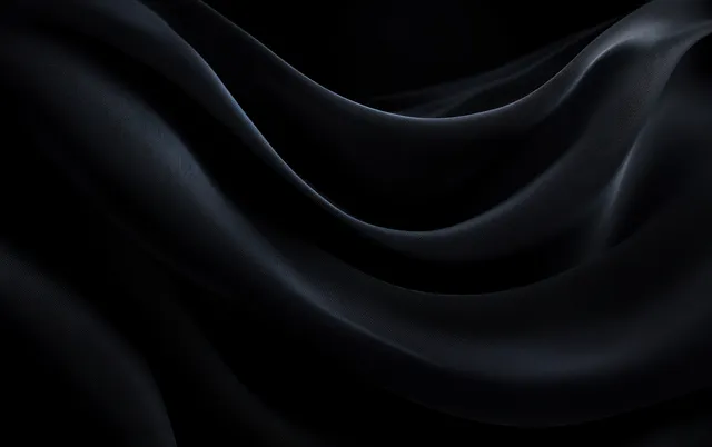 Close-up black fabric drape with soft folds and flowing highlights across silky texture