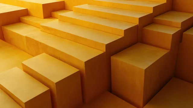 Layered yellow and orange rectangular blocks form interlocking stair steps with deep shadows and strong perspective.