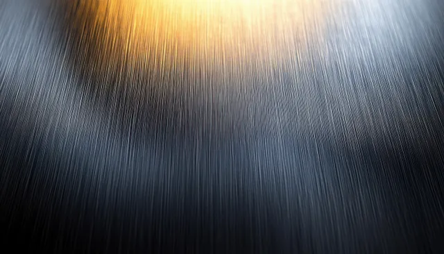 Close-up of brushed stainless steel surface showing diagonal grain and soft reflective highlights.