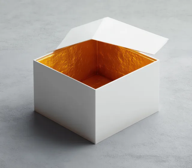 Minimalist white open box on a gray surface showing a golden interior under soft lighting.