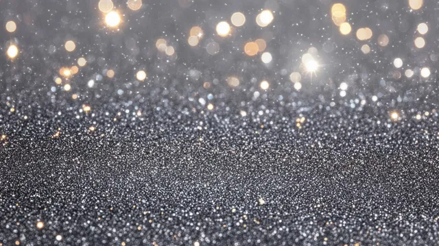 Silver glitter particles scatter across a dark background with warm glowing bokeh